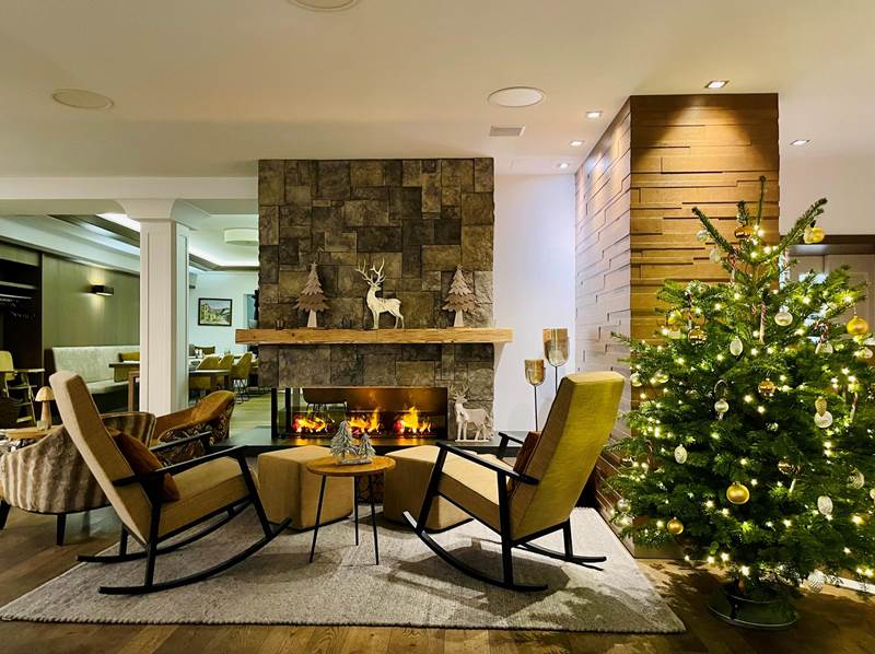 Schaukelstühle und Weihnachtsbaum vor Kamin